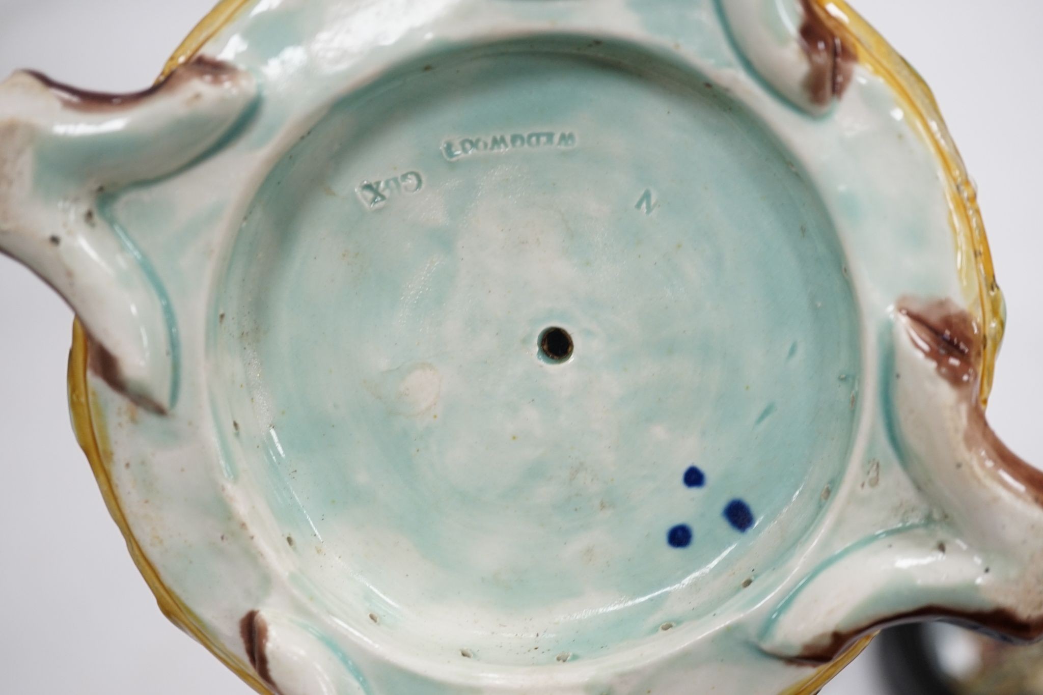 A group of 18th century delftware plates, Wedgwood majolica candlestand (a.f.) and two Victorian framed pot lids